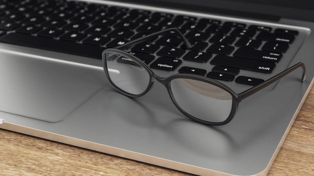 Lunettes professionnelles anti lumière bleue posées sur un ordinateur portable, idéales pour le travail sur écran en 2025